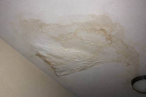Water staining and sagging drywall on a ceiling below a leak
