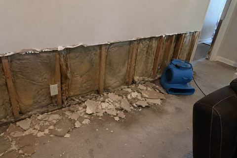 Flood cut with drywall removed to expose wall studs for drying