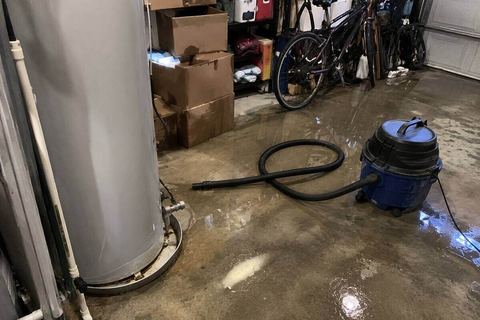 Water spreading across a garage floor from a failed water heater